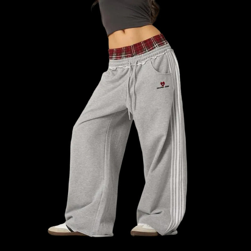 Gray sweatpants with a plaid waistband and red heart logo on a white background
