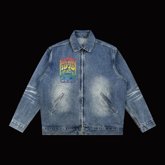 A blue denim jacket with a distressed wash, featuring a colorful retro-style graphic patch on the left chest that reads 'LOVE ALIVE 1975' 