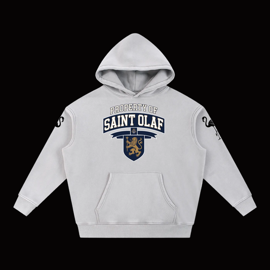 A light gray pullover hoodie with a 'Property of Saint Olaf' graphic on the chest, featuring a navy and gold shield emblem with a lion. The hoodie has black script graphics on both sleeves and is displayed against a solid white background.