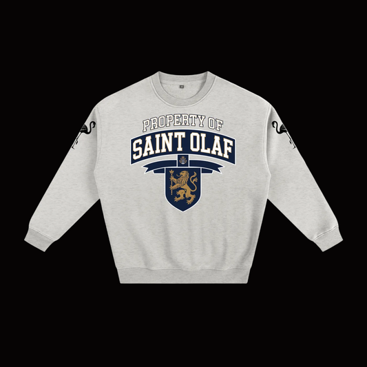 A light heather gray crewneck sweatshirt featuring a 'Property of Saint Olaf' graphic on the chest with a navy banner, gold lion crest, and black sleeve graphics, displayed on a clean white background.