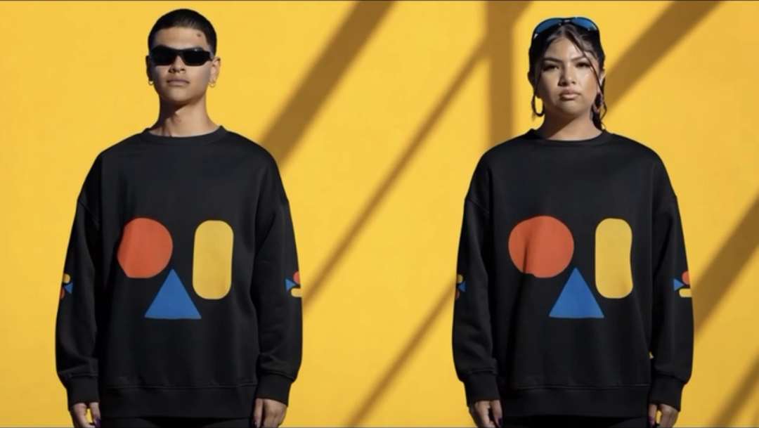 Two models in black 3WD oversized sweatshirts against a yellow wall